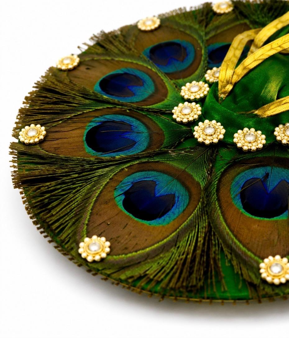 Premium green Kanha poshak decorated with natural peacock feathers and sparkling crystal embellishments.