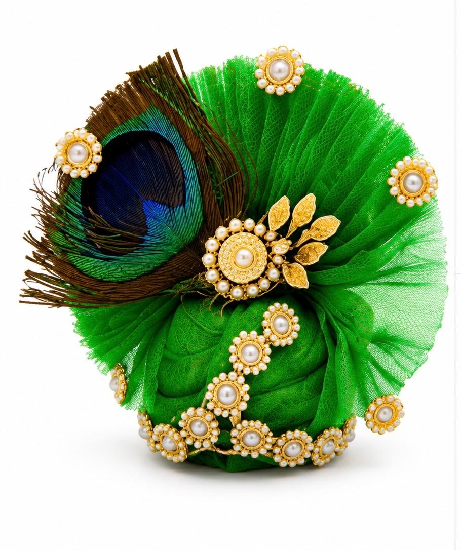 Premium green Kanha poshak decorated with natural peacock feathers and sparkling crystal embellishments.