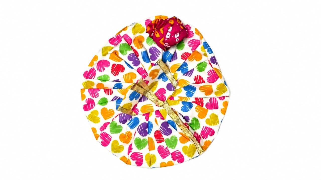 White Laddu Gopal poshak with vibrant heart prints, golden lace, and matching maroon pagdi.