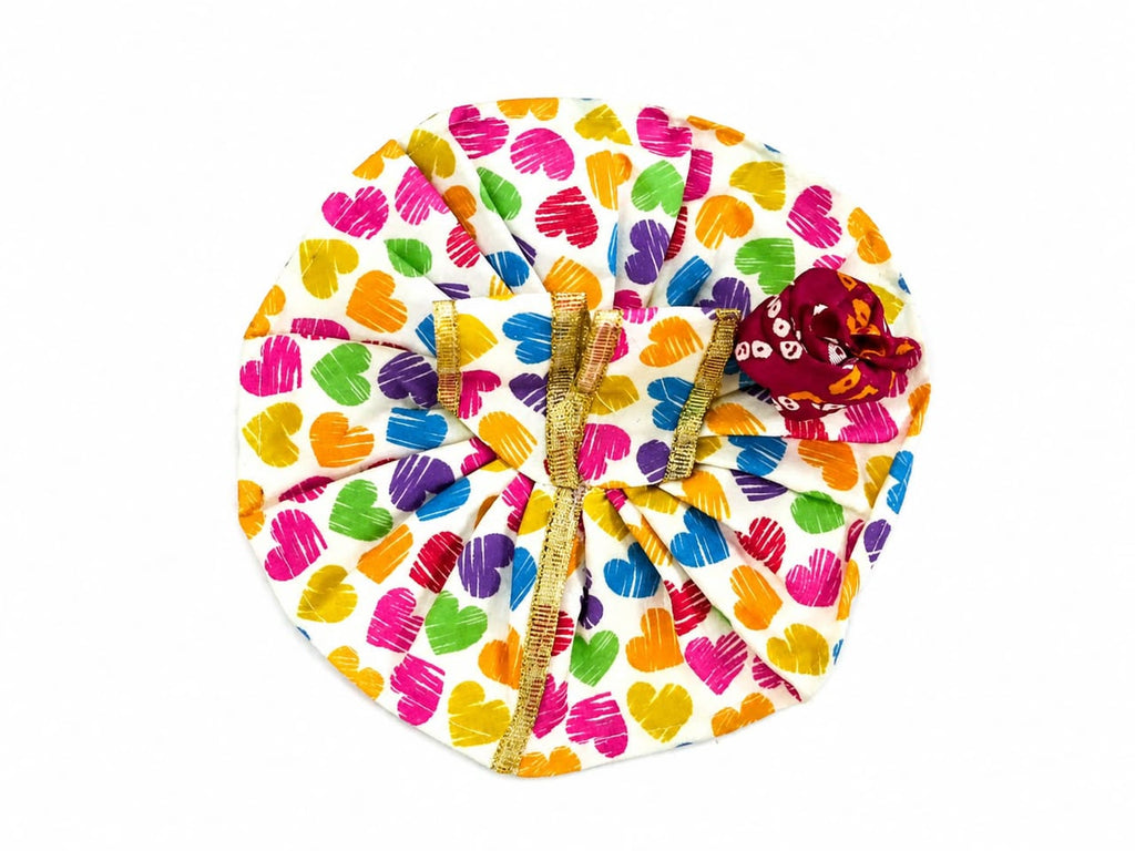 White Laddu Gopal poshak with vibrant heart prints, golden lace, and matching maroon pagdi.